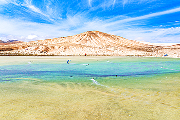 Aerial view of kiteboarders framed by volcanic peaks, Sotavento beach, Jandia, Fuerteventura, Canary Islands, Spain