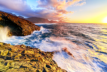 Sunset over the breaking waves washing Cofete Beach, Jandia Nature Park, Fuerteventura, Canary Islands, Spain