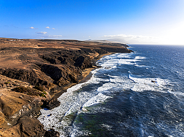 Aerial view of volcanic landscape surrounding La Pared beach washed by waves at sunset, Fuerteventura, Canary Islands, Spain