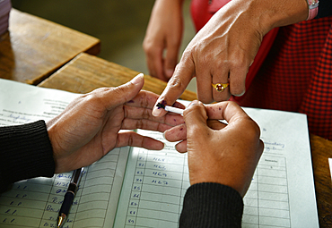 A women gets her finger inked before casting her vote at a polling station