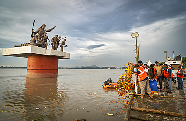 Municipal worker throws religious waste into the Brahmaputra River during immersion of Goddess Durga into the Brahmaputra River on the concluding day of the Durga Puja festival, in Guwahati, Assam, India on 2 October 2025.