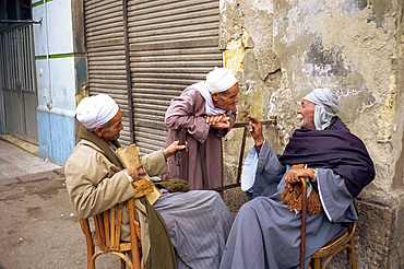 Three old men outside talking in a street in Cairo, Egypt, North Africa, Africa