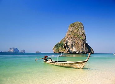 Boat moored on Phranang Beach with limestone stack behind, Krabi, Thailand *** Local Caption ***