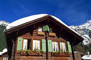 Old wooden chalet with shutters and covered in snow at Wengen in the Bernese Oberland, Switzerland, Europe