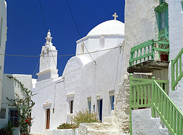 Close-up of green balcony with whitewashed walls, dome and bell tower of church beyond in The Kastro village, Folegandros, Cyclades, Greek Islands, Greece, Europe