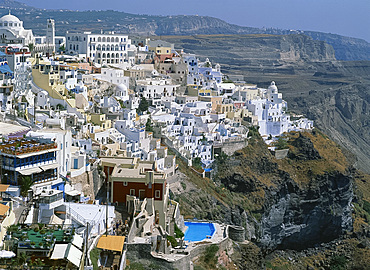 Houses including one with a swimming pool on the hillside in the town of Fira on Santorini (Thira), Cyclades, Greek Islands, Greece, Europe