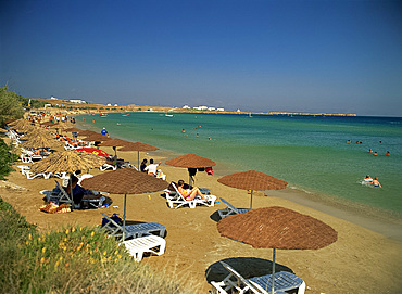 Tourists under sun umbrellas on Golden Beach on Paros, Cyclades, Greek Islands, Greece, Europe