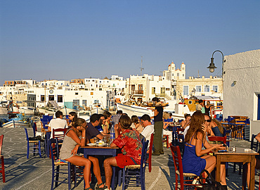 Tourists eating and drinking outside at a taverna in the town of Naousa on Paros, Cyclades, Greek Islands, Greece, Europe