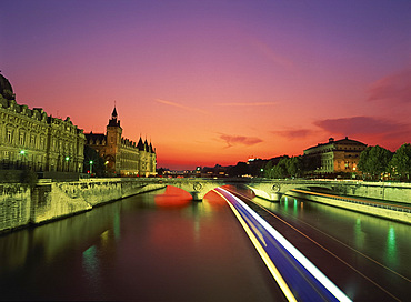 Bateau mouche tourist boat blurred in passing under a bridge on the Seine at night, Paris, France, Europe