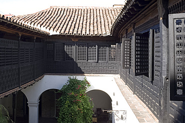 An interior courtyard surrounded by Moorish style wooden screens at the Casa de Diego Velazquez (Museo de Ambiente Historico Cubano), Santiago de Cuba, Cuba, West Indies, Central America