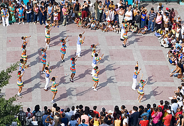 School kids in fancy costumes dancing at a festival in Parque Cespedes, Santiago de Cuba, Cuba, West Indies, Central America