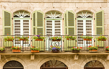 Colourful wooden shutters and a flower covered balcony in Dinan, Brittany, France, Europe