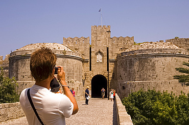 A tourist taking a photograph at D'Amboise Gate, Rhodes Town, Rhodes, Dodecanese, Greek Islands, Greece, Europe