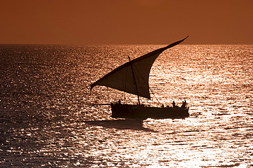 A dhow sailing at sunset near Stone Town, Zanzibar, Tanzania, East Africa, Africa