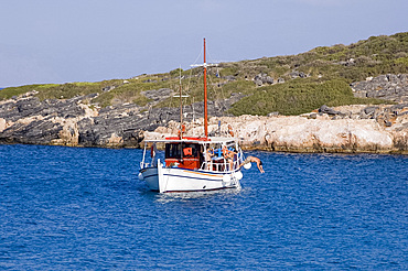 A boy diving off a boat near the island of Spinalonga near Elounda, Crete, Greek Islands, Greece, Europe