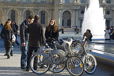 Tourists at the fountains in front of the Louvre with rented Velib bicycles, Paris, France, Europe