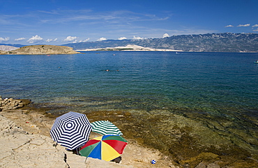 Beach umbrellas by the sea at San Marino, island of Rab, Kvarner region, Croatia, Europe