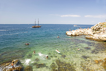 People swimming off the rocky coast at Rovinj, Istria, Croatia, Adriatic, Europe