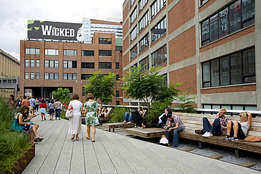 People sitting on wooden lounge chairs and strolling on the newly created High Line park area on an old rail line in lower Manhattan, New York City, New York State, United States of America, North America