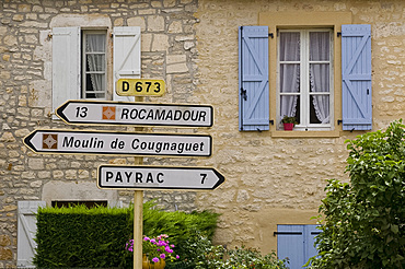 Road signs in front of an old house in the Dordogne region of France, Europe