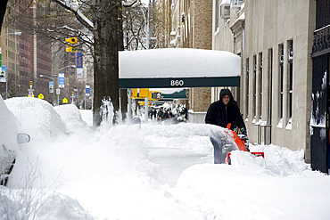 A man using a snow blower on Park Avenue after a blizzard in New York City, New York State, United States of America, North America