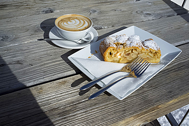 Apple strudel and cappuccino at a mountain restaurant in the Dolomites, South Tyrol, Italy, Europe