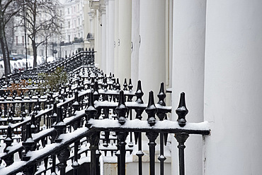 Snow covered iron railings in front of houses in the Notting Hill area of London, England, United Kingdom, Europe