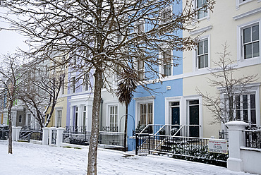 Pastel coloured houses on a snowy day in Elgin Crescent in the Notting Hill area of London, England, United Kingdom, Europe