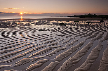 Ripples of sand near Dunstanburgh Castle in Embleton Bay at sunrise, Northumberland, England, United Kingdom, Europe