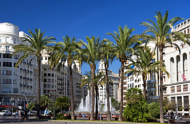 Palm trees, high rise buildings and a fountain in Plaza del Ayuntamiento in Valencia, Valenciana, Spain, Europe