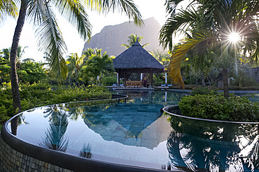 Le Morne Brabant behind an infinity pool at sunrise at the Lux Le Morne Hotel. Le Morne Brabant Peninsula, south west Mauritius, Indian Ocean, Africa