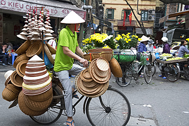 A man selling Vietnamese Conical straw hats and baskets from his bicycle in the Old Quarter, Hanoi, Vietnam, Indochina, Southeast Asia, Asia