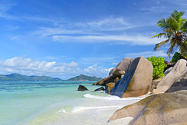 Waves swirling around large granite boulders and palm trees on Anse Source d'Argent, La Digue, Seychelles, Indian Ocean, Africa