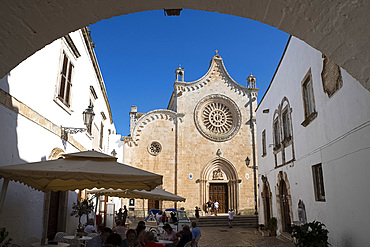 A view through an arch to the rose window on the Cathedral of Santa Maria dell Assunzione in Ostuni, Puglia, Italy, Europe