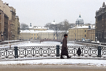 Figure crossing bridge over the Griboedon Canal in winter, St. Petersburg, Russia, Europe