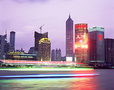 View across river at dusk to the new Pudong district skyline, Huangpu River, Shanghai, China, Asia