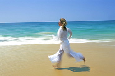 Woman running along beach, Kovalam, Kerala state, India, Asia