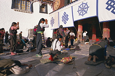 Tibetan Buddhist pilgrims prostrating at the Jokhang temple, Barkhor, Lhasa, Tibet, China, Asia