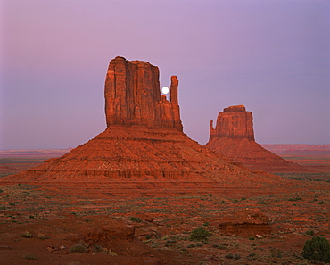 The moon above the rock formations known as The Mittens in the Navajo Reservation in Monument Valley, Utah, United States of America, North America