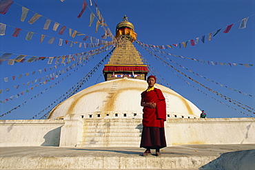 Buddhist monk in front of the largest stupa in Nepal, at Bodhnath, UNESCO World Heritage Site, Kathmandu, Nepal, Asia