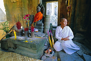 Buddhist nun meditating in the Bayon Temple, at Angkor, Siem Reap, Cambodia