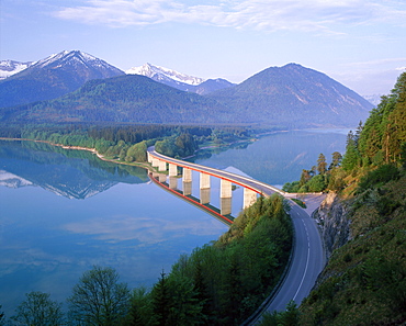 Reflections of a road bridge over Lake Sylvenstein, with mountains in the background, in Bavaria, Germany *** Local Caption ***