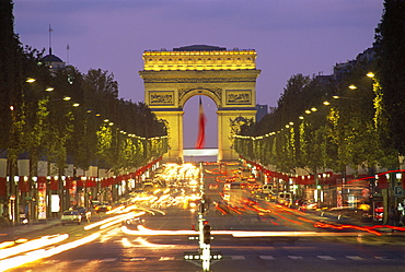 View down the Champs Elysees to the Arc de Triomphe, illuminated at dusk, Paris, France *** Local Caption ***