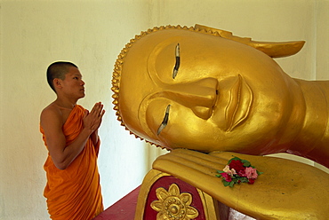 Novice monk and reclining Buddha, Wat Pha Baat Tai, Luang Prabang, Laos, Indochina, Southeast Asia, Asia