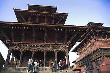 Local people sitting on temple steps, Durbar Square, UNESCO World Heritage Site, Patan, Bagmati, Nepal, Asia