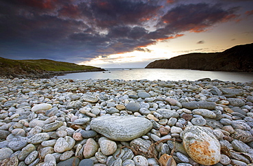 Looking out to sea at sunset across the rocky beach at Gearranin, Isle of Lewis, Outer Hebrides, Scotland, United Kingdom, Europe