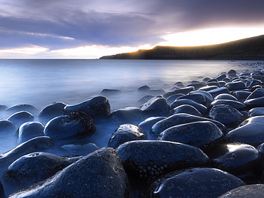 Embleton Bay at dawn from beach of basalt boulders known as The Rumble Churn, near Alnwick, Northumberland, England, United Kingdom, Europe