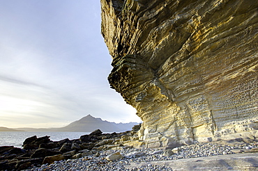 Honeycombe Rock bathed in evening light with Cuillin Hills in distance, Elgol, Isle of Skye, Highland, Scotland, United Kingdom, Europe