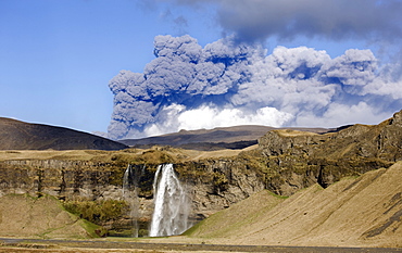 Distant view of the Seljalandsfoss waterfall with the ash plume of the Eyjafjallajokull eruption in the distance, near Hella, southern Iceland, Iceland, Polar Regions