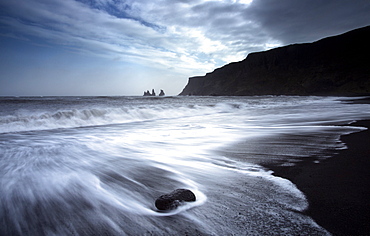 The rockstacks of Reynisdrangar from the black volcanic sand beach at Vik i Myrdal, South Iceland, Iceland, Polar Regions